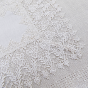 detail of an intricate square lace doily or table centre